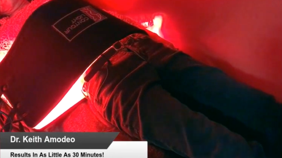 Patient receiving non-invasive fat reduction treatment with red light therapy on abdominal area