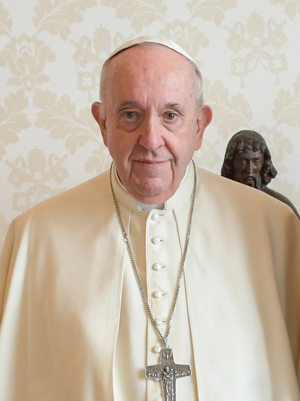 Pope Francis in white attire, greeting crowd outdoors