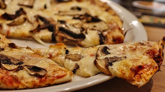 Two men chatting at a colorful table in a local cafe, promoting support for local restaurants.
