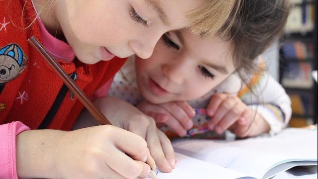 Arkansas invests in literacy and preschool education text overlay on woman's top.