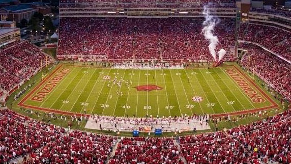 Arkansas football coaching staff press conference with confident speaker.