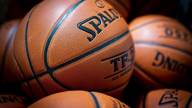 Arkansas Razorbacks local hero soaring for a impressive dunk in high school basketball arena.