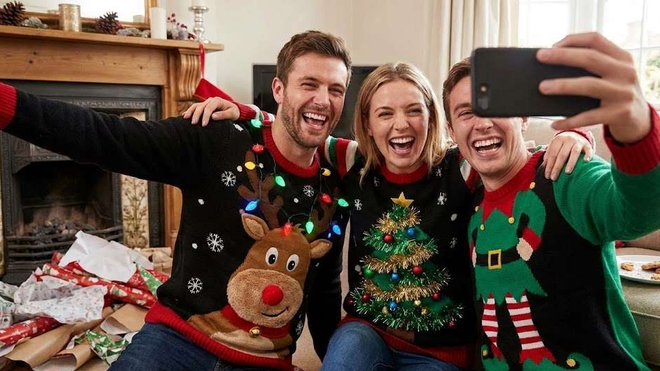 Celebrating National Ugly Christmas Sweater Day with festive attire.