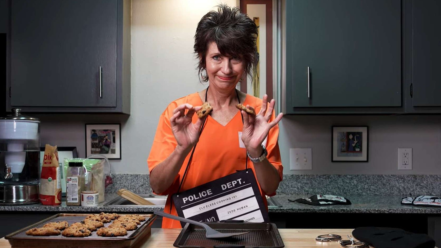 Frustrated woman with burnt cookies in modern kitchen.
