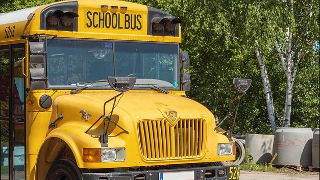 Close-up of yellow school bus emergency door sign.