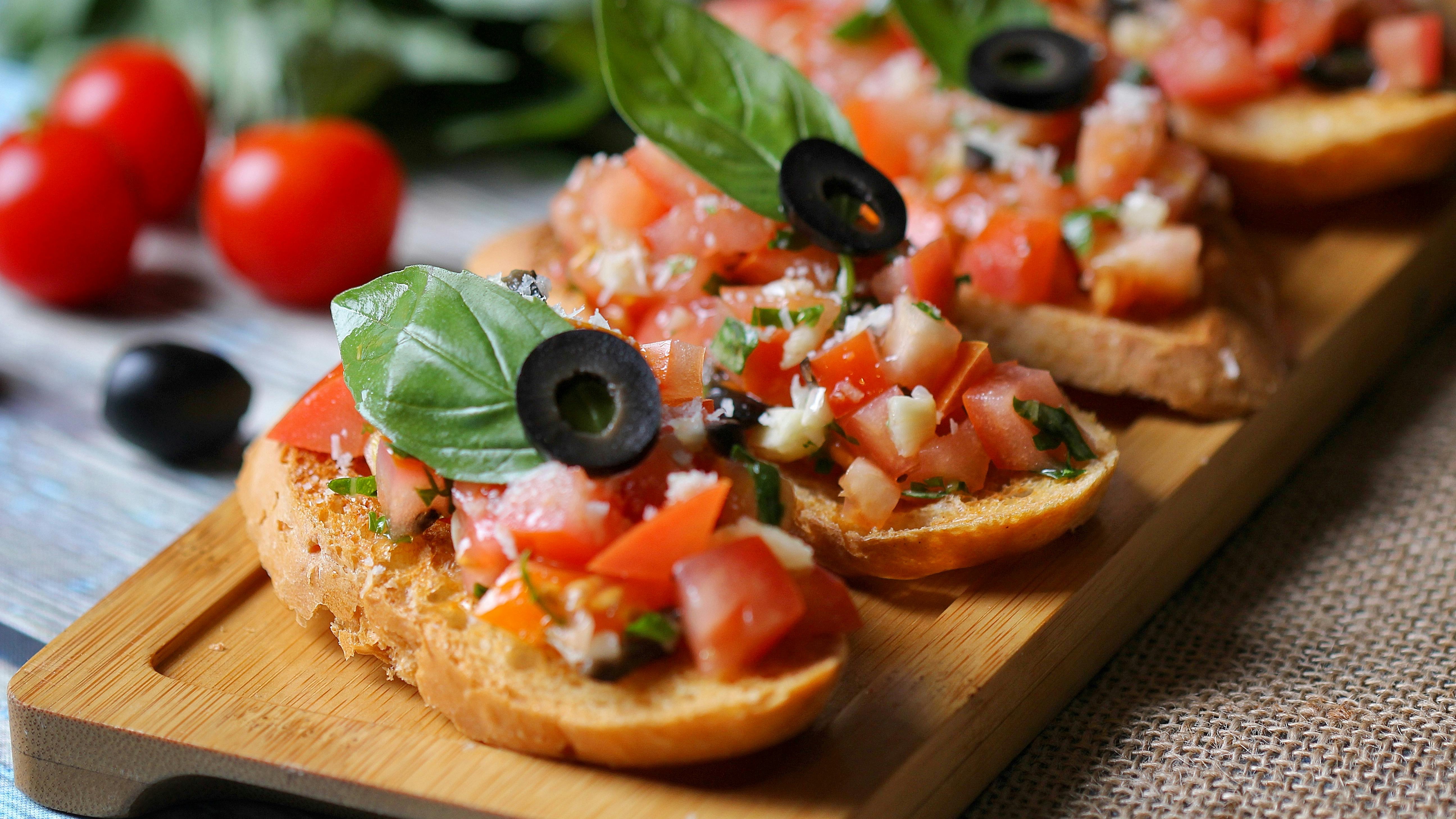 Woman prepares crunchy bruschetta in modern kitchen.