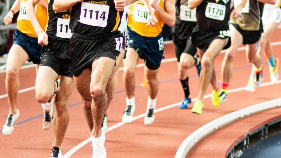 Arkansas track athlete sprinting intensely during a race, highlighting performance.