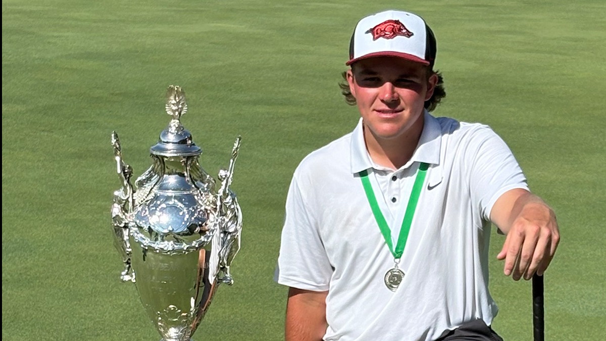 John Daly II wins Southern Amateur, kneeling with trophy on a golf course.