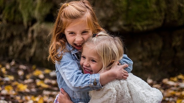 two friends kids hugging each other in happiness