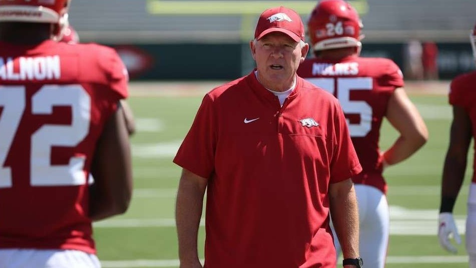 Arkansas Razorbacks coach instructing players on field