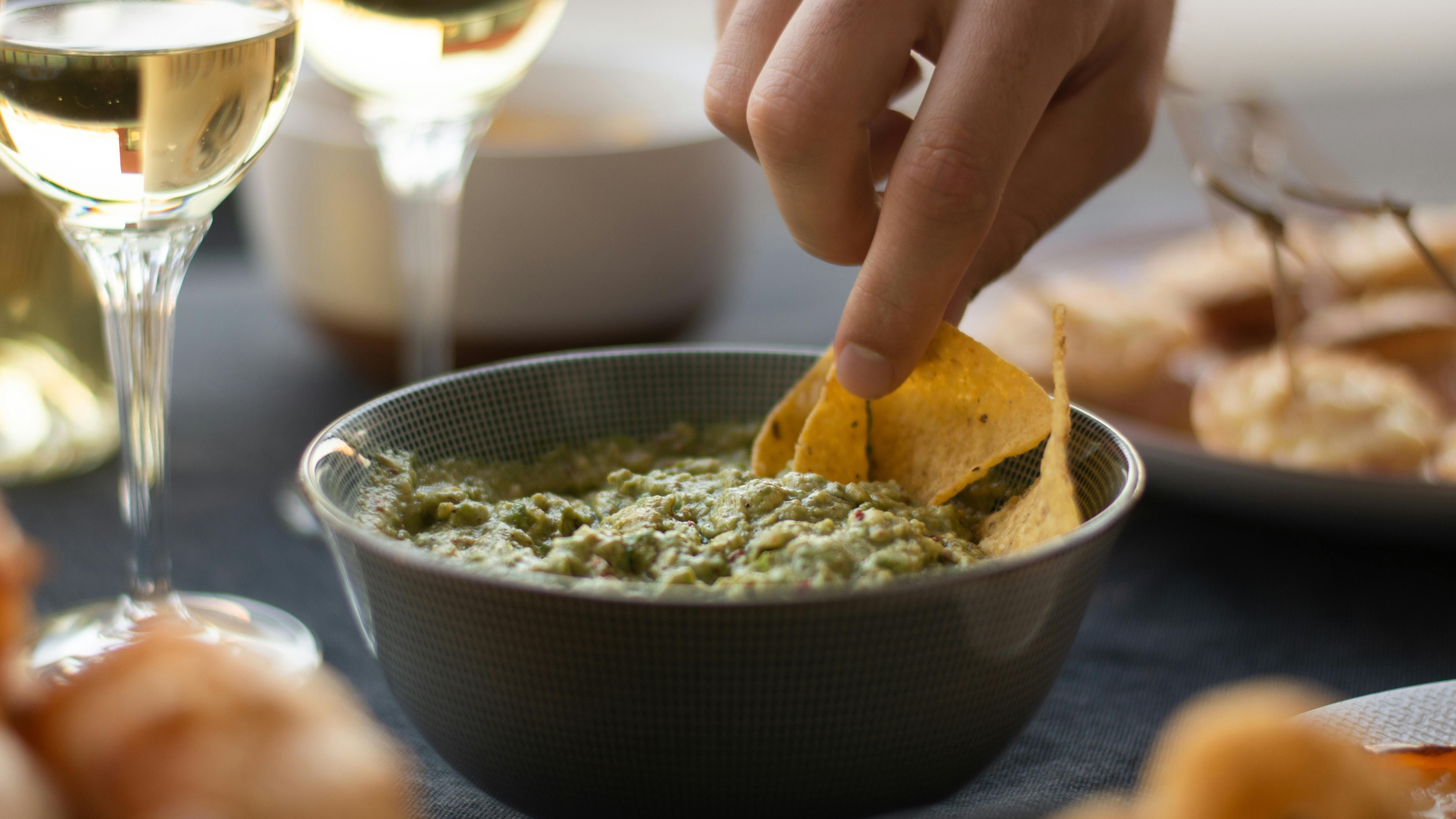 Middle-aged woman preparing guacamole, cooking tips.