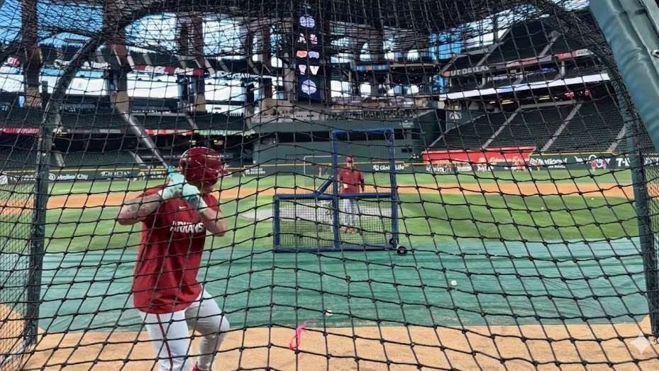 Razorbacks baseball player practicing in indoor stadium.