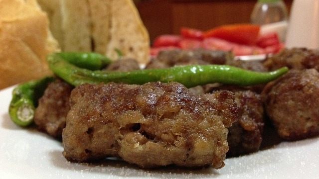 Bearded man discussing Mama's Meatballs in a lively restaurant.