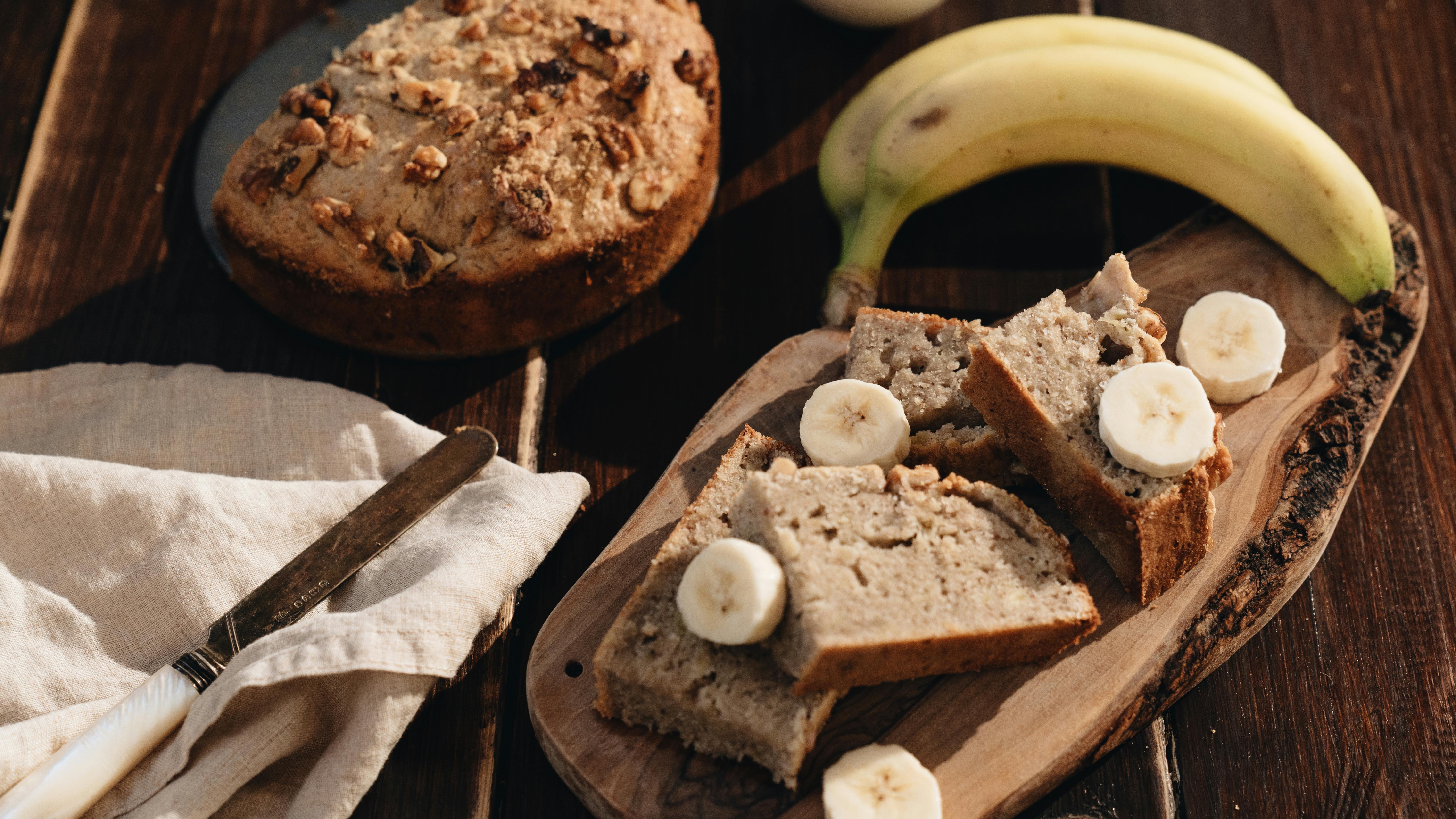 Moist banana bread with banana slices and walnuts for National Banana Bread Day.