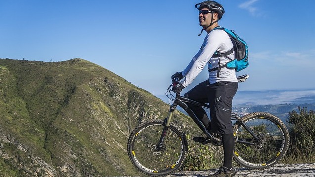 Northwest Arkansas mountain biking destination, rider on forest trail.