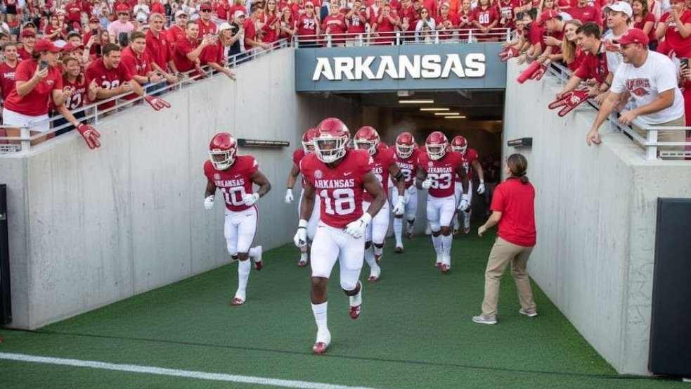 Arkansas Razorbacks press conference with smiling man.