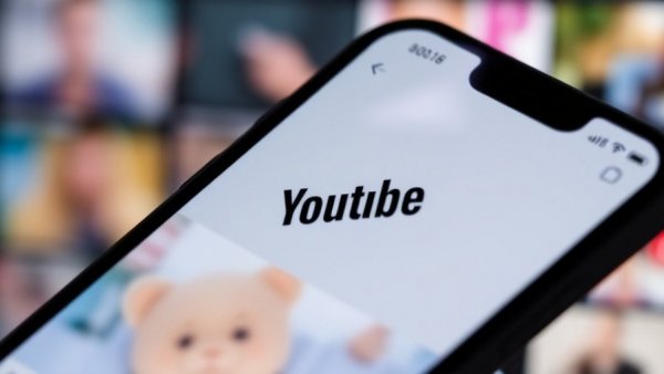 Smartphone showing YouTube logo with video thumbnails, vibrant and clear.