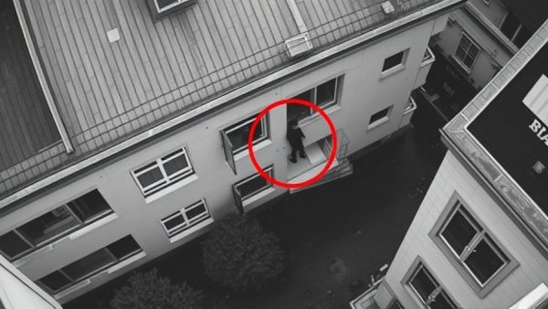 Surveillance footage showing a suspect in a window during an incident.