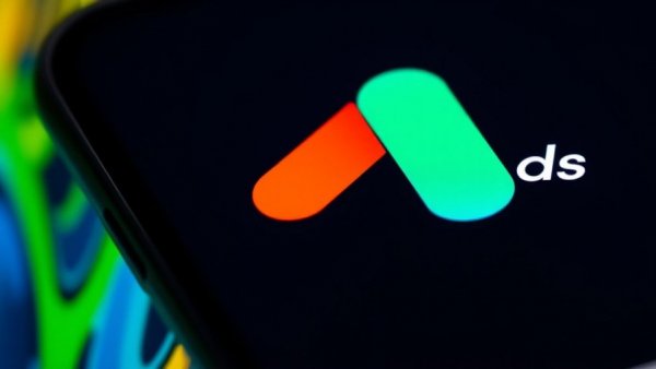 Google Ads logo on phone screen, colorful blurred background.
