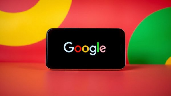 Smartphone displaying Google logo on colorful background.