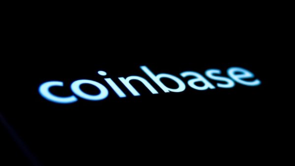 Reflective blue Coinbase logo on smartphone screen, dark backdrop.