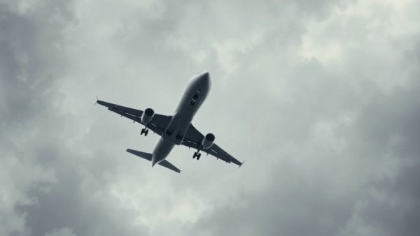 Airplane flying against cloudy sky, related to FAA directives and flight cancellations.
