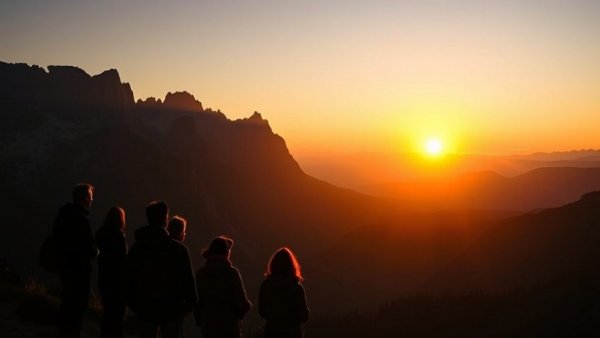Tourists silhouetted against U.S. national park mountains at sunset.