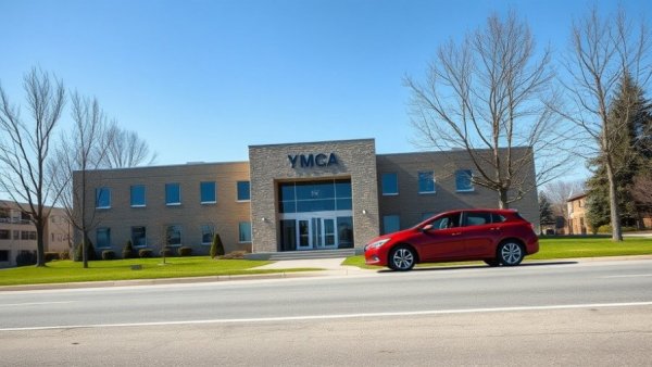 YMCA building with red car parked outside and clear blue sky.
