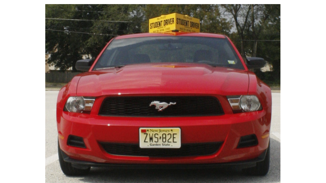 Proficient driver, intense expression, navigating through a rainstorm, photorealistic, highway with blurred headlights, highly detailed, raindrops on windshield, f/1.4 aperture, monochrome tones, diffused lighting, shot with a 105mm macro lens.