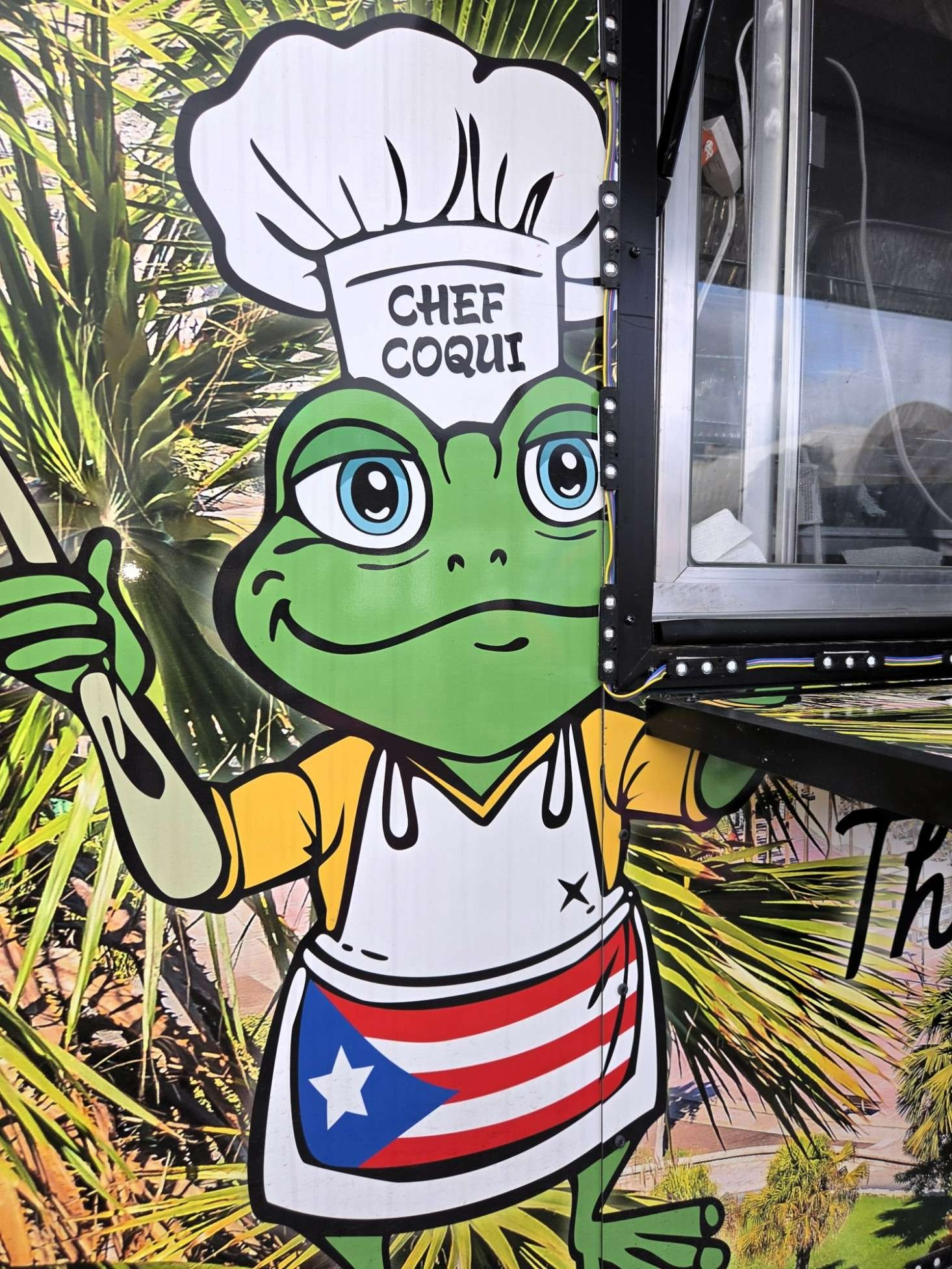 Chef Coqui character with Puerto Rican colors on the El Gran Coqui Catering food trailer