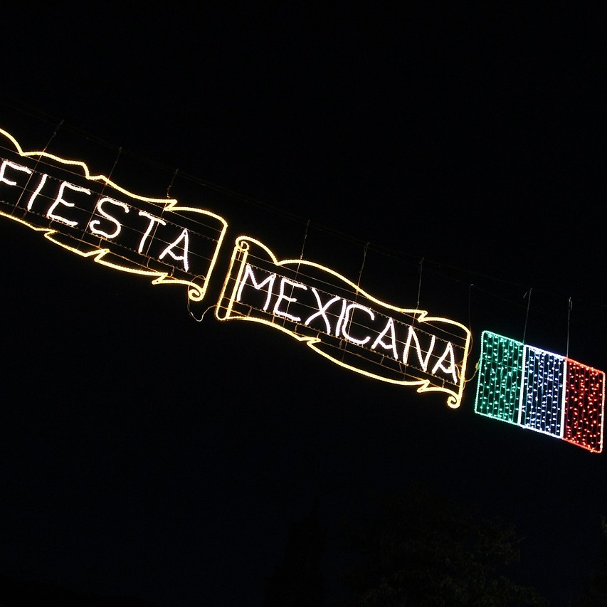 neon banner that says "fiesta mexicana" with colors of mexican flag