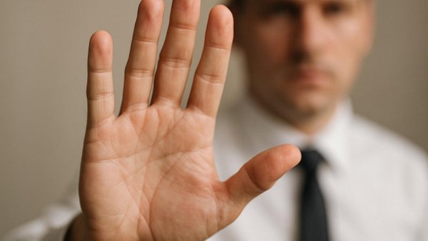 Person signaling stop in business attire, South Dakota Total Loss Bill context.