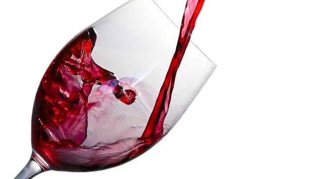 Glass of red wine with measuring tape and weight loss question text.