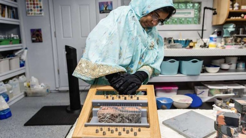 Skincare formulator cutting soap made with natural ingredients in small-batch workshop reflecting thoughtful handmade skincare