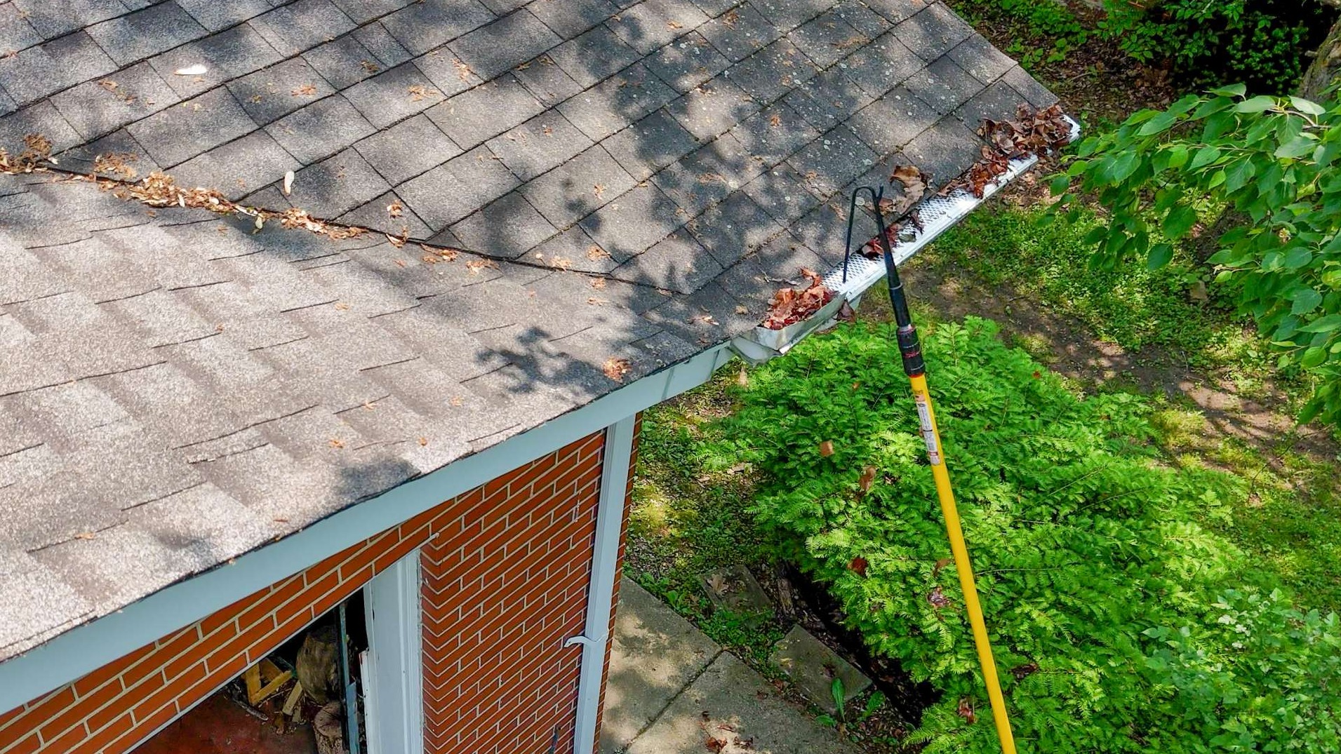 The Sputter®️ on an extension pole being used to unclog a gutter downspout