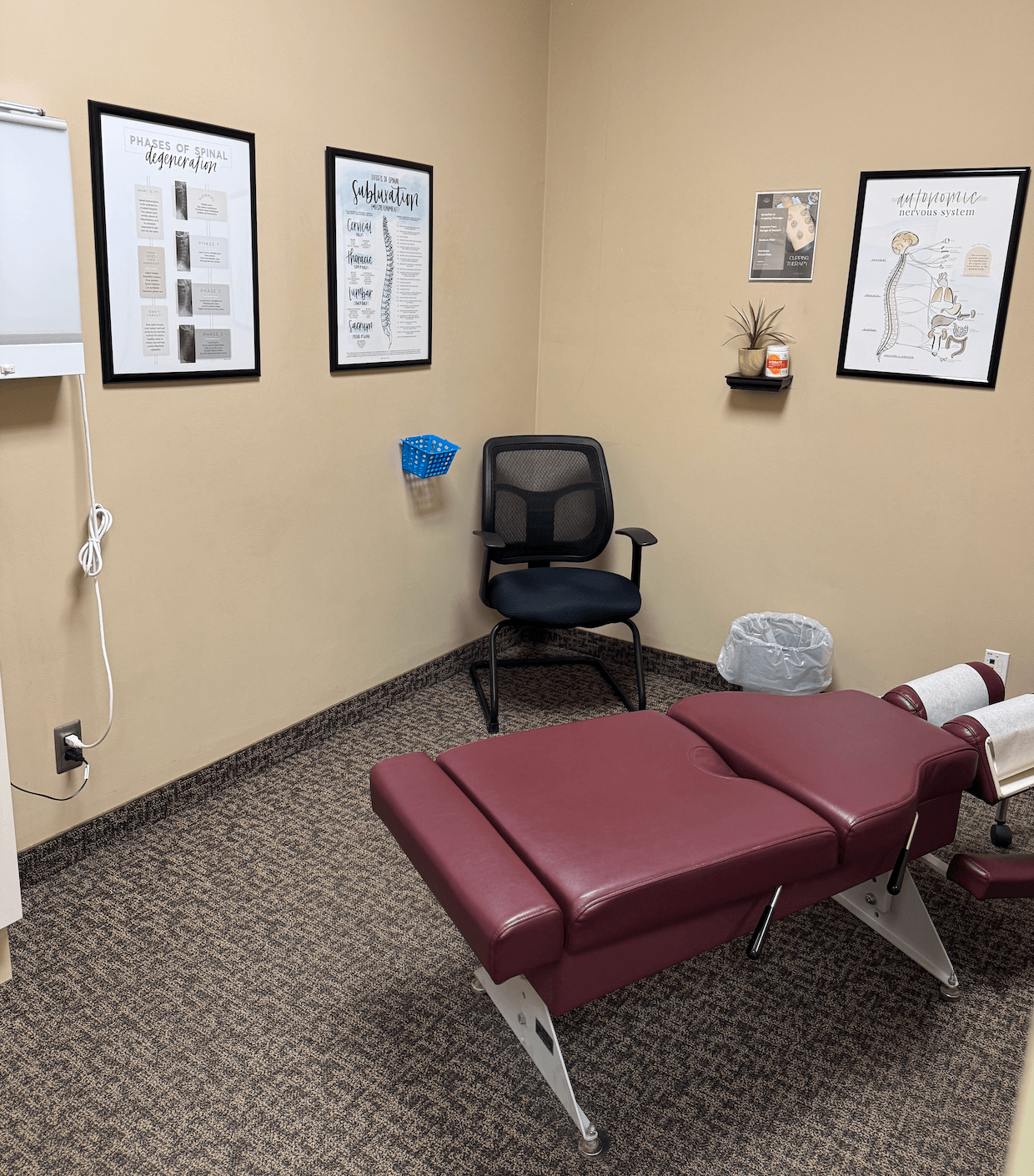 Patient treatment room at Farmington Chiropractic shows adjustment table and pictures on the wall