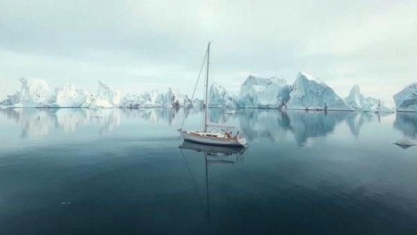 Yacht with marine generator cruising near glaciers.