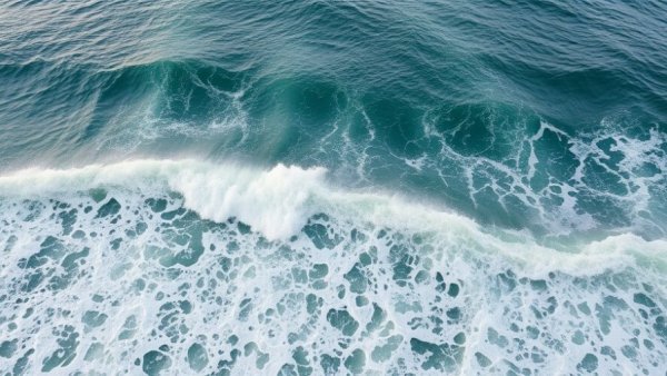 Aerial view of tidal bore in an expansive ocean landscape.