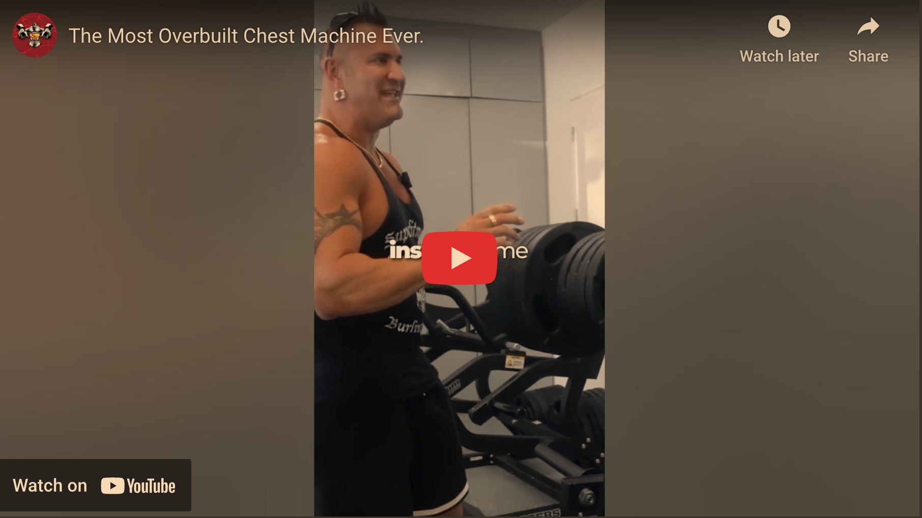 Muscular individual with an overbuilt chest machine, smiling at gym.
