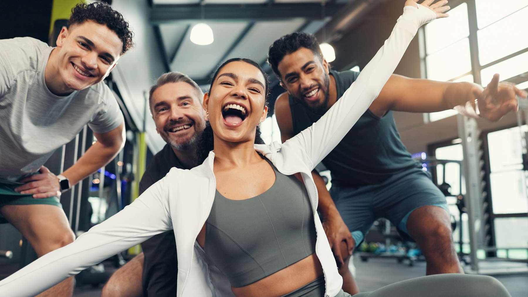 Energetic diverse athletes mid-workout in a stylish gym, showcasing emotion and power.