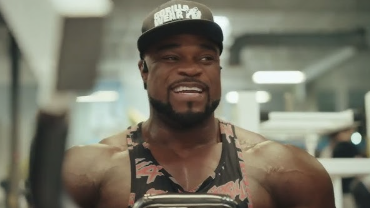 Brandon Curry showcasing bodybuilding success on a vibrant backdrop.