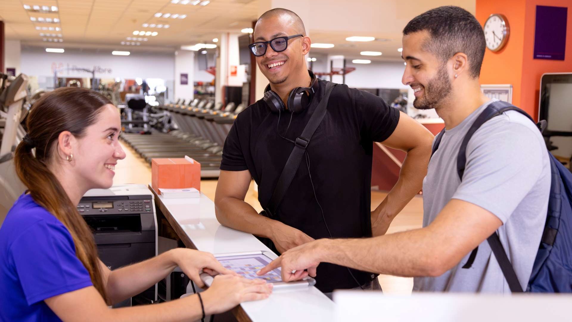 Inviting gym reception area with happy members and modern design, illustrating gym referrals in action.