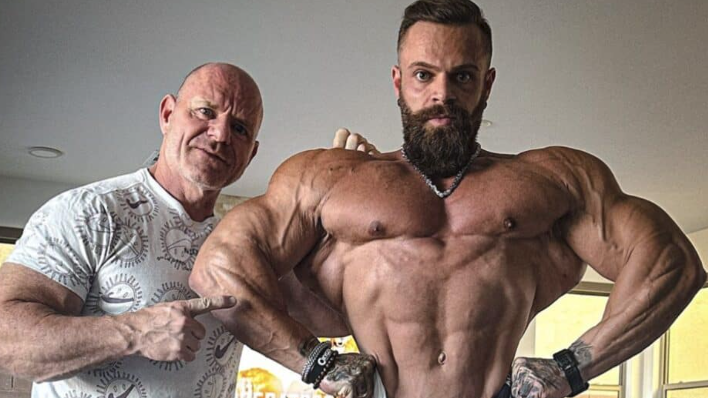 Bodybuilder posing confidently on stage at a fitness event.