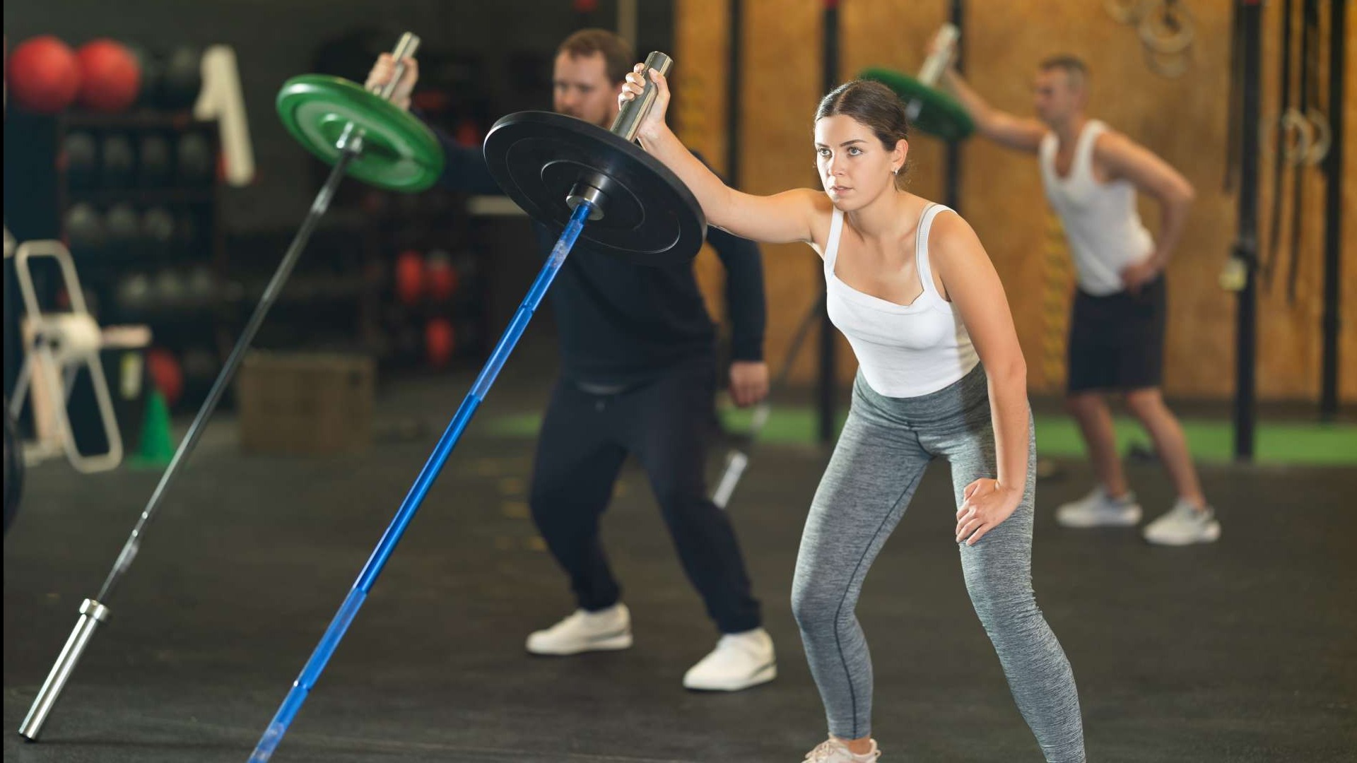 Young woman demonstrating benefits of landmine training in gym.