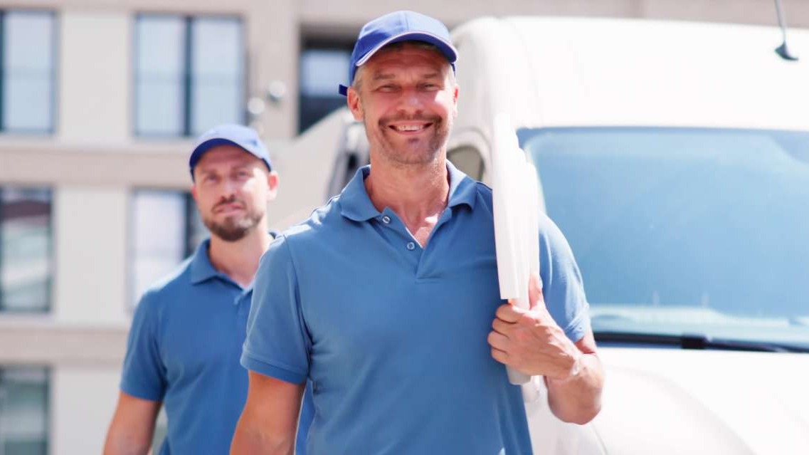 Professional in front of HVAC system for Dual Fuel Solutions discussion.