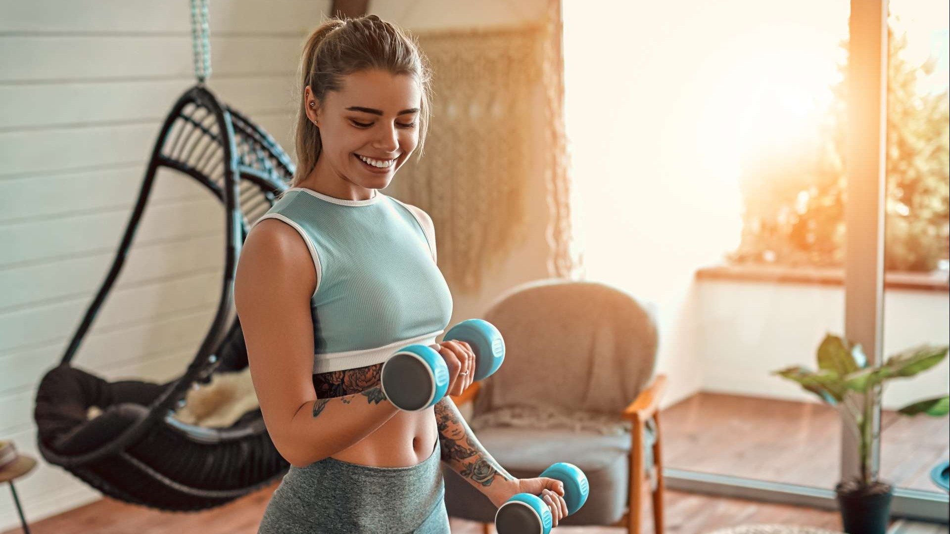 Energetic fitness enthusiast lifting adjustable weights at home, bright and motivating.