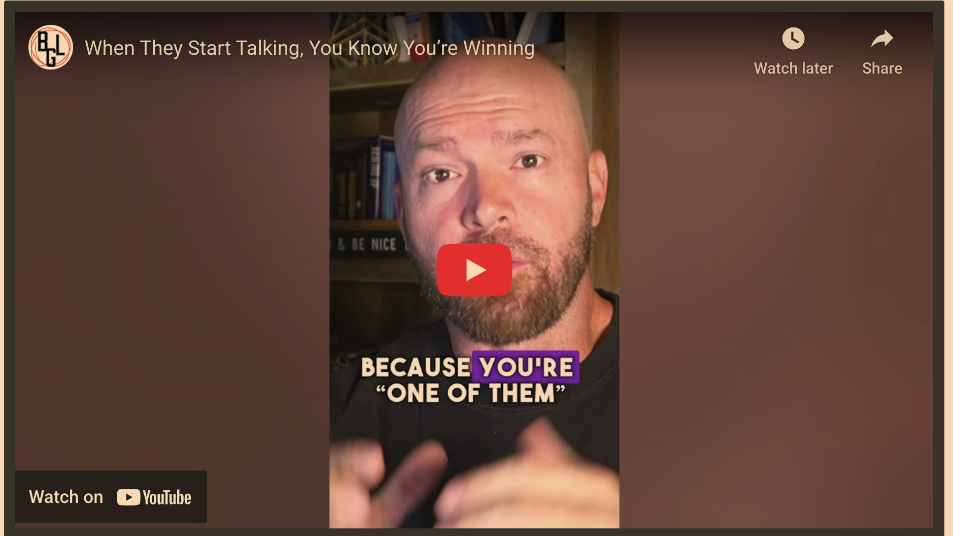 Bald man discussing success in fitness conversations, warm indoor scene.
