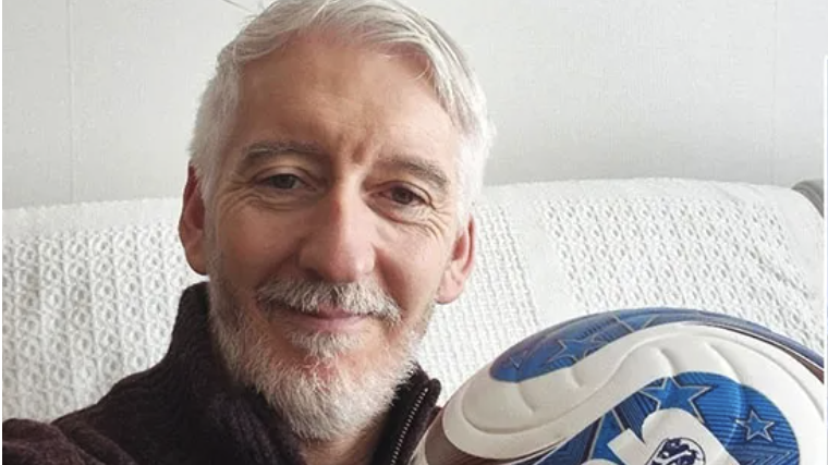 Older man staying fit after 50 by playing soccer indoors.