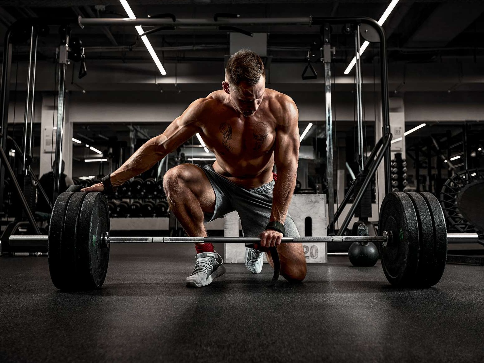 Focused athlete chalking hands, determination evident in gritty gym light.