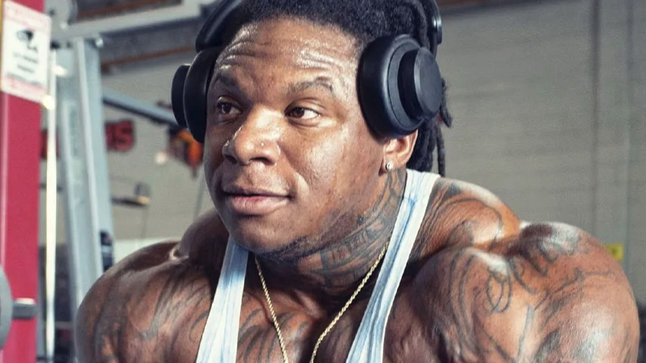 Bodybuilder displaying muscle definition, gym setting, Tonio Burton Cable Fly Technique.